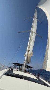 Lastovo, Hırvatistan - 14 Haziran 2025: Hırvatistan yakınlarındaki bir yatın pruvasından görülen rüzgar dolu beyaz yelkenliler. Özgürlük, temiz enerji, macera ve açık denizde dikkatli bir yolculuk.. 