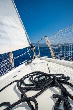 Hırvatistan yakınlarındaki bir yelkenli yatının pruvasında uzanan siyah ip. Denizci müfrezesi, navigasyon, güç ve denizde hareket. Yüksek kalite fotoğraf