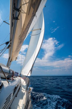 Denizi yarıp geçen bir yatın yanında Hırvatistan yakınlarında yelkenler açılıyor. Hareket, özgürlük, yelkencilik yaşam tarzı ve açık denizde macera. Yüksek kalite fotoğraf