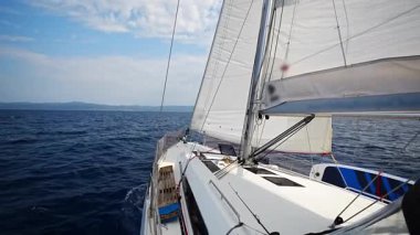 Tüm yelkenliler Hırvatistan yakınlarındaki açık denizde son sürat giden bir yat. Dinamik deniz macerası ve okyanus yolculuğu özgürlüğü. Yüksek kalite 4k görüntü