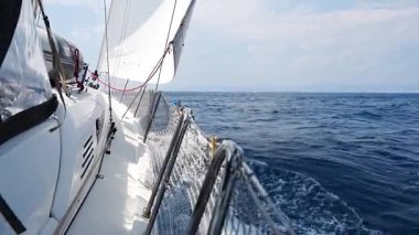 Denizi yarıp geçen bir yatın yanında Hırvatistan yakınlarında yelkenler açılıyor. Hareket, özgürlük, yelkencilik yaşam tarzı ve açık denizde macera. Yüksek kalite 4k görüntü