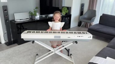 Evde müzik dersi sırasında piyano çalmayı reddeden küçük bir kız. Erken çocukluk öğrenme sürecinde oyuncu direniş ve duygusal ifade. Yüksek kalite 4k görüntü