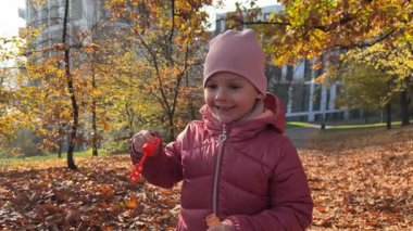 Prag 'daki sonbahar parkında baloncuk çıkaran küçük bir kız. Yüksek kalite 4k görüntü