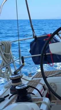 Hırvatistan yakınlarındaki seyrüsefer sırasında direksiyonu, vinçleri ve ipleri olan bir yelkenli yatının kokpiti. Denizde yelken ekipmanları, kontrol ve yaşam tarzı. Yüksek kalite 4k görüntü