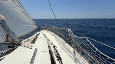 Denizi boydan boya geçen yelkenli bir yatın pruvası. Hırvatistan yakınlarında yelkenler tamamen açık. Özgürlük, hareket, temiz enerji ve açık denizde yavaş yolculuk. Yüksek kalite 4k görüntü