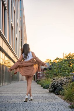 Çekici genç bir kadın gün batımında boş zamanlarının tadını çıkarıyor. Yazın mutlu kız portresi. Özgürlük yaşam tarzı yaz konsepti. Arka planda güneş parlıyor. Yüksek kalite fotoğraf