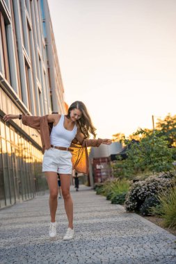 Çekici genç bir kadın gün batımında boş zamanlarının tadını çıkarıyor. Yazın mutlu kız portresi. Özgürlük yaşam tarzı yaz konsepti. Arka planda güneş parlıyor. Yüksek kalite fotoğraf