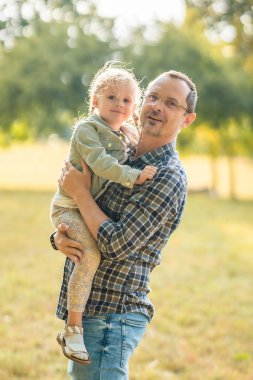 Genç baba ve komik küçük kız Prag, Avrupa 'nın gün batımında sonbahar parkında birlikte vakit geçiriyorlar. Yüksek kalite fotoğraf