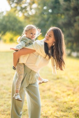 Anne ve komik küçük kız Prag, Avrupa 'nın gün batımında sonbahar parkında birlikte eğleniyorlar. Yüksek kalite fotoğraf