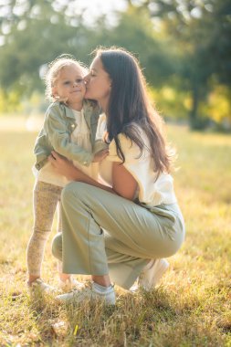 Genç anne ve küçük kızı Prag, Avrupa 'daki sonbahar parkında öpüşüp oynuyorlar. Yüksek kalite fotoğraf