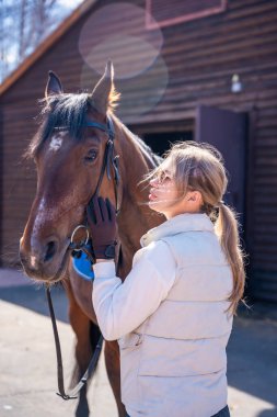 Köy çiftliğinde at taşıyan genç bir kadının portresi. Kırsal yaşam tarzı ve kırsal zarafet kavramı. Yüksek kalite fotoğraf