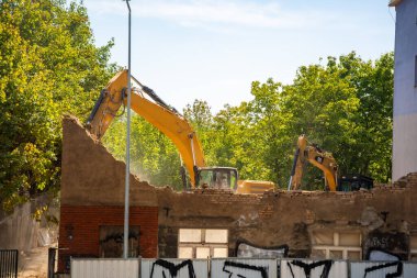 Prag, Çek Cumhuriyeti - 28 Ağustos 2025: Kazıcı bir şehir caddesinde eski bir binayı yıkıyor. Kentsel yeniden yapılanma, yapısal parçalanma ve şehir mimarisinin dönüşümü kavramı. 