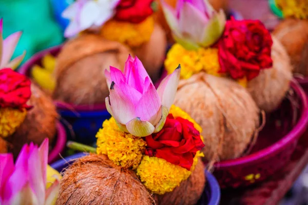stock image Pealed coconuts, lotus , rose and other flowers prepared for pooja, ritual worship in a temple, selective focus