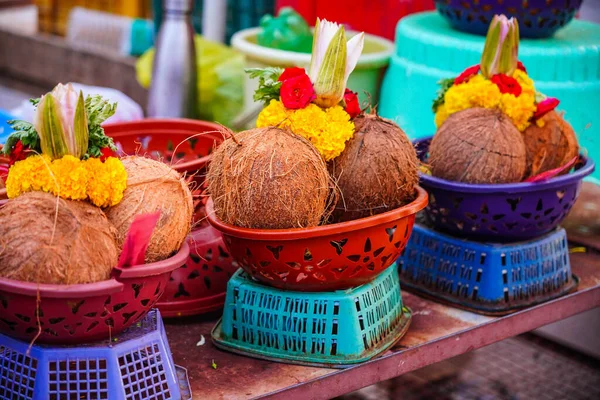 Soyulmuş hindistan cevizleri, nilüfer, gül ve pooja için hazırlanmış diğer çiçekler, tapınakta ayin ibadeti, seçici odak