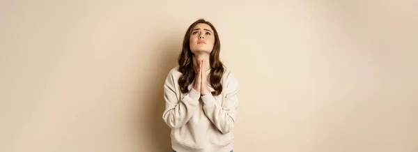 女人祈求和恳求上帝 站在绝望的米色背景 复制空间 — 图库照片
