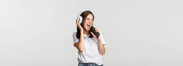 Karaoke Uygulaması Çalan Akıllı Telefona Şarkı Söyleyen Kablosuz Kulaklık Takan — Stok fotoğraf
