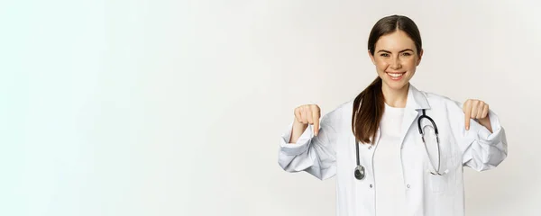 Portrait Happy Female Doctor Pointing Fingers Smiling Demonstrating Promo Offer — Stok fotoğraf