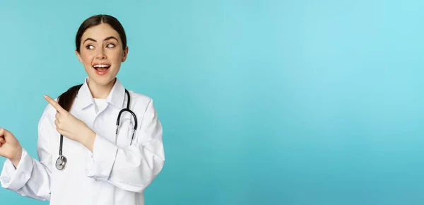 Πορτρέτο Του Χαμογελαστού Ιατρό Κορίτσι Γιατρός Λευκό Παλτό Στηθοσκόπιο Δείχνοντας — Φωτογραφία Αρχείου