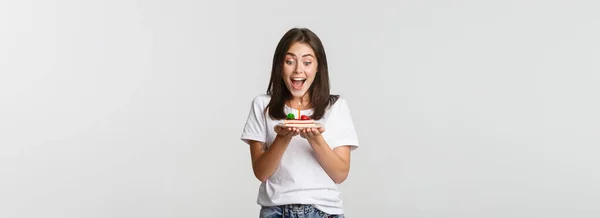 兴奋迷人的黑发女孩在生日蛋糕上许愿 白色背景 — 图库照片