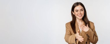 Portrait of smiling businesswoman extend hand for handshake, greeting business partner, saleswoman welcome client, white background.
