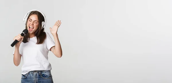 Kaygısız Gülümseyen Kız Karaoke Yapıyor Mikrofonda Kulaklıkla Şarkı Söylüyor — Stok fotoğraf