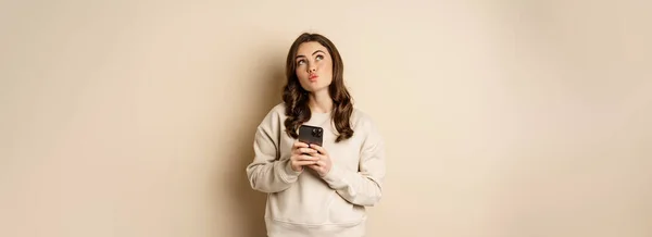 Zakupy Online Cute Girl Myślenia Trzymając Telefon Komórkowy Obrazowanie Smth — Zdjęcie stockowe