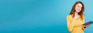 İnsan ve teknoloji kavramı - portre genç güzel çekici Dişileştirilmiş kız dijital masada bir şey yeme içme ile gülümseyen mutlu yakın. Mavi Pastel renkli. Kopya alanı.