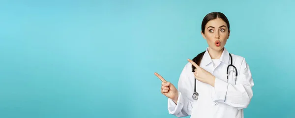 Zaskoczona Lekarka Lekarz Stetoskopem Wskazująca Patrząca Lewo Zdumioną Zadziwiającą Twarzą — Zdjęcie stockowe