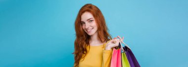 Alışveriş kavramı - portre genç güzel çekici Dişileştirilmiş kız kameraya alışveriş çantası ile seyir gülümseyen yakından. Mavi Pastel renkli. Kopya alanı.