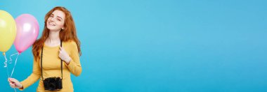 Yaşam tarzı ve parti kavramı - yakın çekim portre genç güzel çekici Kızıl kızıl saçlı kız ile renkli balon ve vintage fotoğraf makinesi. Mavi Pastel renkli. Kopya alanı