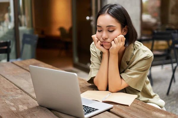 退屈した女の子は彼女のラップトップを見て カフェで屋外に座って 退屈なオンライン会議を聞いて 仕事と悲しい感じ — ストック写真