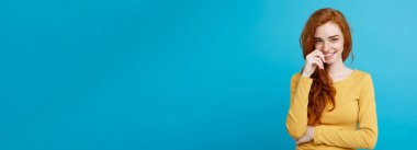 Yaşam tarzı kavramı - portre genç güzel çekici Kızıl kızıl saçlı kız saçını utangaçlık ile oynamaktan yakından. Mavi Pastel renkli. Kopya alanı