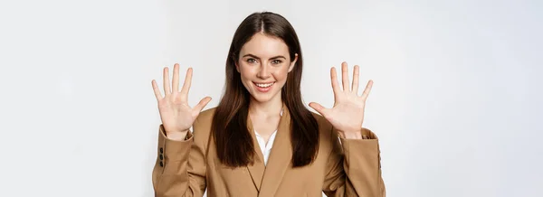 stock image Portrait of corporate woman, saleswoman showing number ten fingers and smiling, standing in suit over white background.