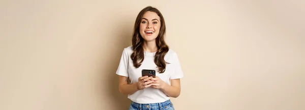 幸せな現代の女性は スマートフォンや笑顔を保持し 携帯電話技術と携帯電話の概念 — ストック写真