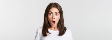 Etkilenmiş kızın yakın plan fotoğrafı. Çenesini indir. Şaşırmış, beyaz arkaplan..