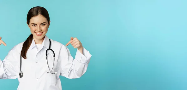 Gülümseyen Doktor Sağlık Görevlisi Logoyu Işaret Eden Klinik Afişi Gösteren — Stok fotoğraf