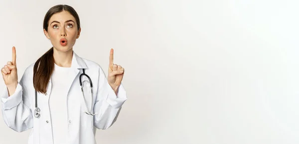 Médico Bonito Feliz Médico Feminino Apontando Dedos Para Cima Mostrando — Fotografia de Stock