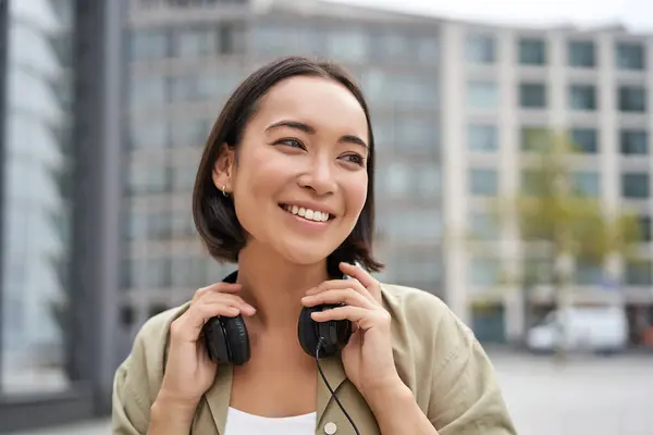 Retrato Chica Asiática Sonriente Con Auriculares Posando Centro Ciudad Escuchando —  Fotos de Stock