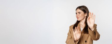 Embarrassed woman turn away from something disgusting, refusing, rejecting, standing displeased against white background.