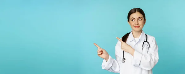 Muotokuva Hymyilevä Lääkäri Tyttö Lääkäri Valkoisessa Takissa Stetoskooppi Osoittaa Sormella — kuvapankkivalokuva
