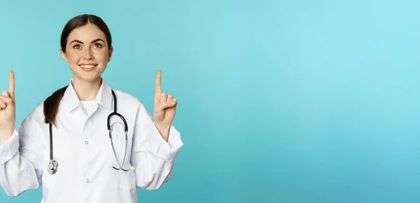 Begeistertes Medizinisches Personal Junge Ärztin Weißem Mantel Stethoskop Werbung Zeigend — Stockfoto