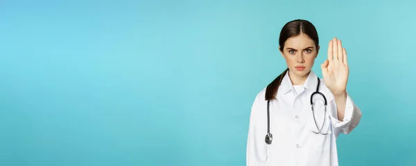 Ciddi Görünümlü Genç Doktor Kadın Tıbbi Klinik Çalışanı Durduğunu Gösteriyor — Stok fotoğraf