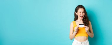 Buna ihtiyacın var. Gülümseyen, ima eden, sana göz kırpan, plastik kredi kartı gösteren, temassız ödeme öneren, mavi arka planda duran çekici bir kadın..