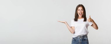 Tatmin olmuş çekici kız elinde bir şey tutuyor ve onayını veriyor..