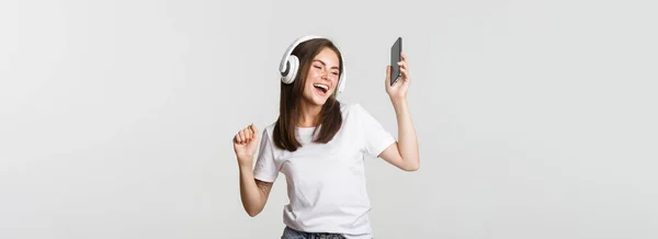 Feliz Hermosa Chica Morena Bailando Escuchando Música Auriculares Inalámbricos Sosteniendo —  Fotos de Stock