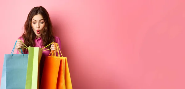 Aufgeregtes Mädchen Öffnet Einkaufstüten Und Keucht Erstaunt Schaut Sich Vor — Stockfoto