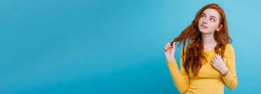 Kameraya bakarak gülen çiller ile mutlu Kızıl kızıl saçlı kız portresi. Pastel mavi arka plan. Kopya alanı.