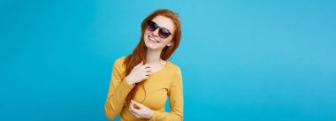 Seyahat kavramı - trendy sunglass gülümseyen genç güzel çekici Kızıl kızıl saçlı kız portre yakından. Mavi Pastel renkli. Kopya alanı