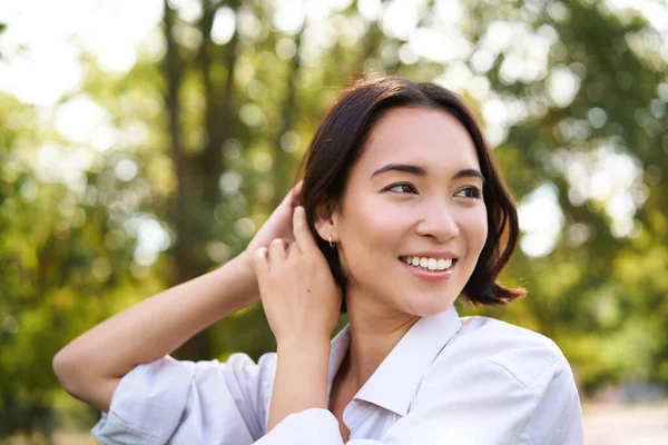 stock image Women and beauty. Portrait of young happy asian woman walking on streets, enjoying stroll in park, smiling and looking around.