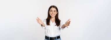 Enthusiastic laughing woman, smiling and stretching out arms forward, welcome you, greeting, standing over white background.
